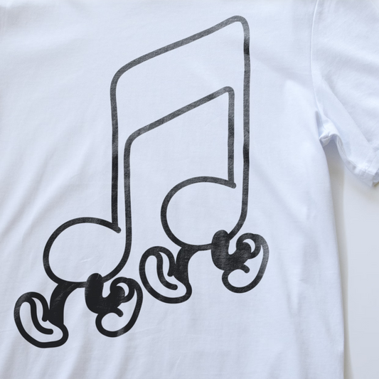 Close up of a synth t-shirt with an illustration of a large black walking musical note graphic printed on the front.