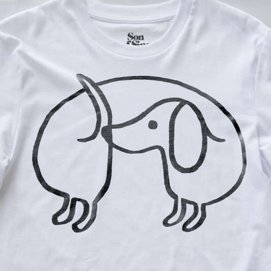Close up of en electronic music t-shirt featuring a minimalist black line art graphic of a dachshund dog on the front. The inner collar label shows the brand name 'Son of Sine'.