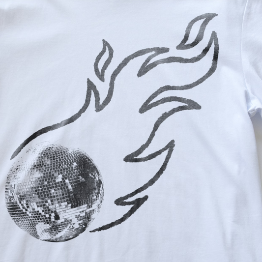 White electronic music t-shirt featuring a graphic print of a silver disco mirror ball with black flame-like lines rising from it.