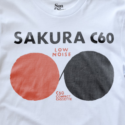 White cotton electronic music t-shirt featuring a graphic print for 'Sakura C60 Low Noise C60 Compact Cassette'.
