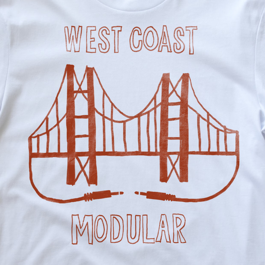 Close up of a white synth t-shirt, featuring an illustration of the Golden Gate Bridge with the text 'WEST COAST MODULAR' printed in red.