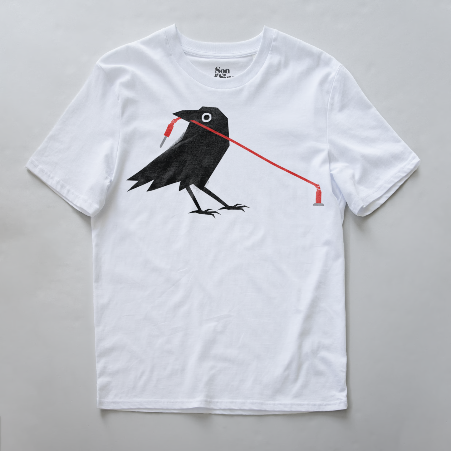 A modular synth t-shirt featuring a graphic print of a black crow holding a red patching cable in its beak.