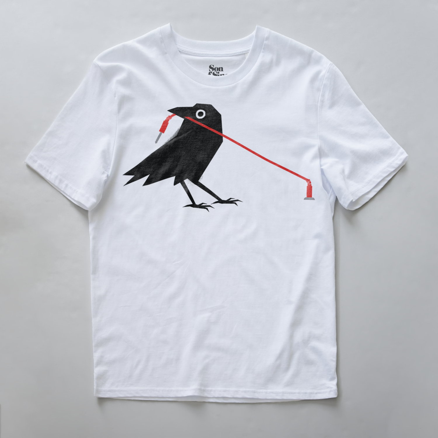 A modular synth t-shirt featuring a graphic print of a black crow holding a red patching cable in its beak.