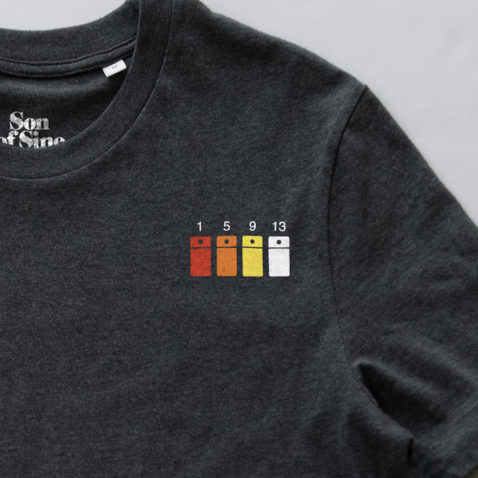 Close-up of a Roland 808 synth t-shirt featuring a graphic of four steps sequencer buttons.