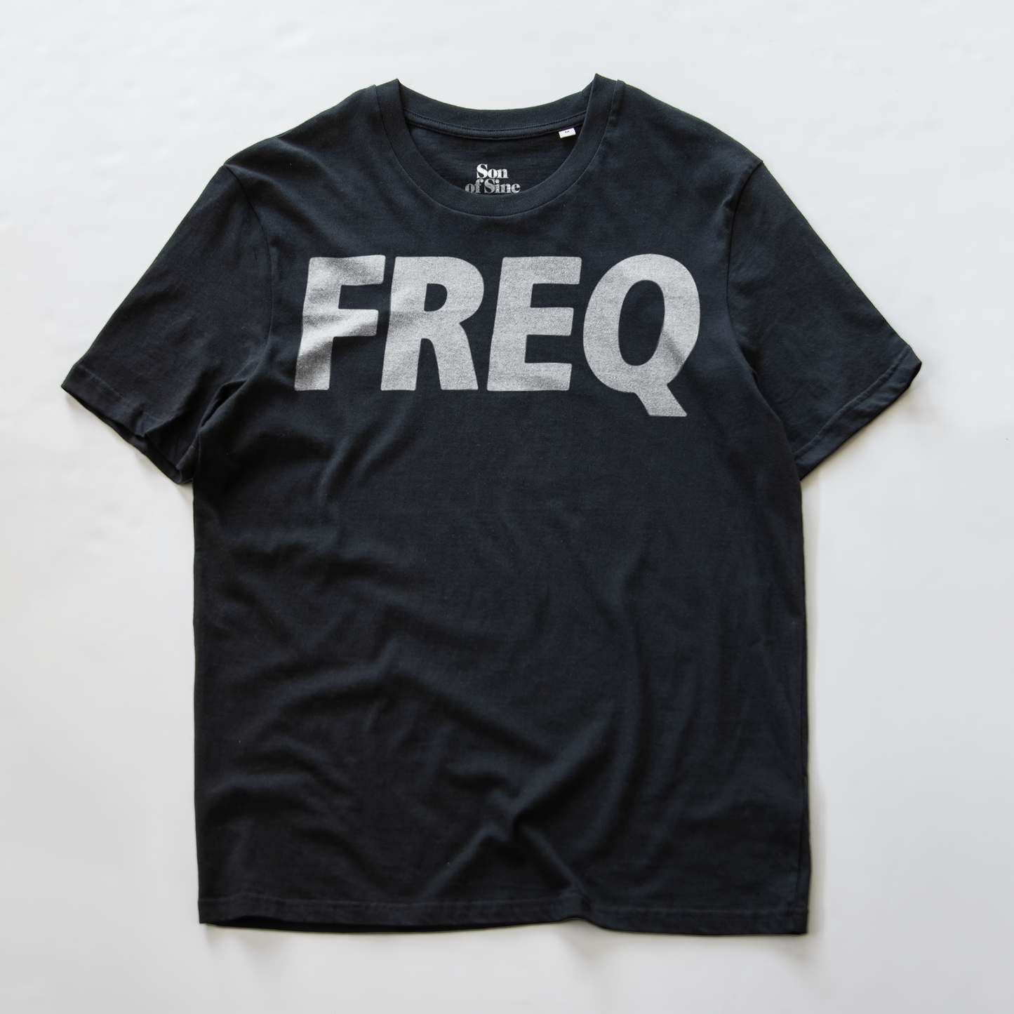 An electronic music club wear t-shirt with the word 'FREQ' printed across the chest in a white ALLl CAPS font.