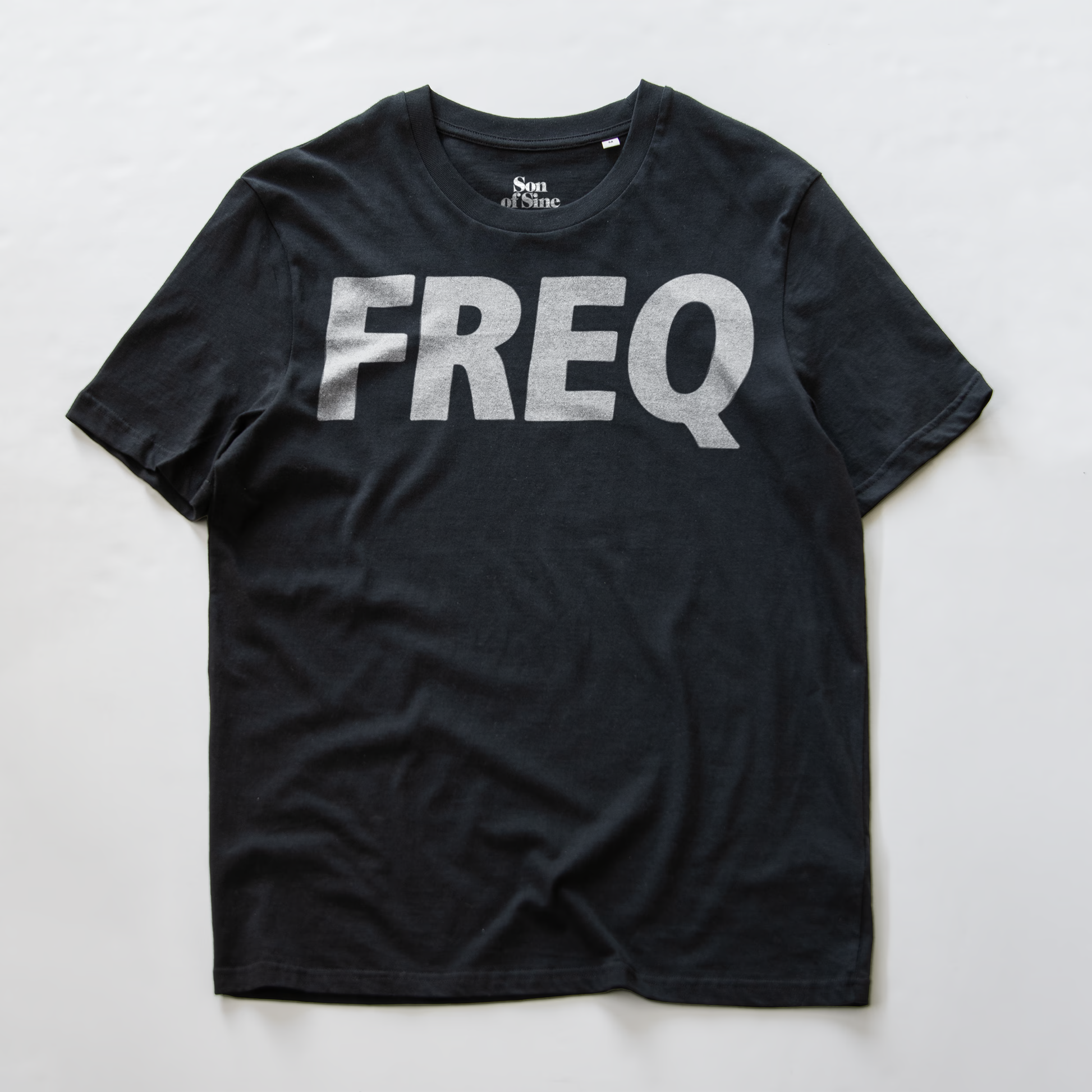 An electronic music club wear t-shirt with the word 'FREQ' printed across the chest in a white ALLl CAPS font.