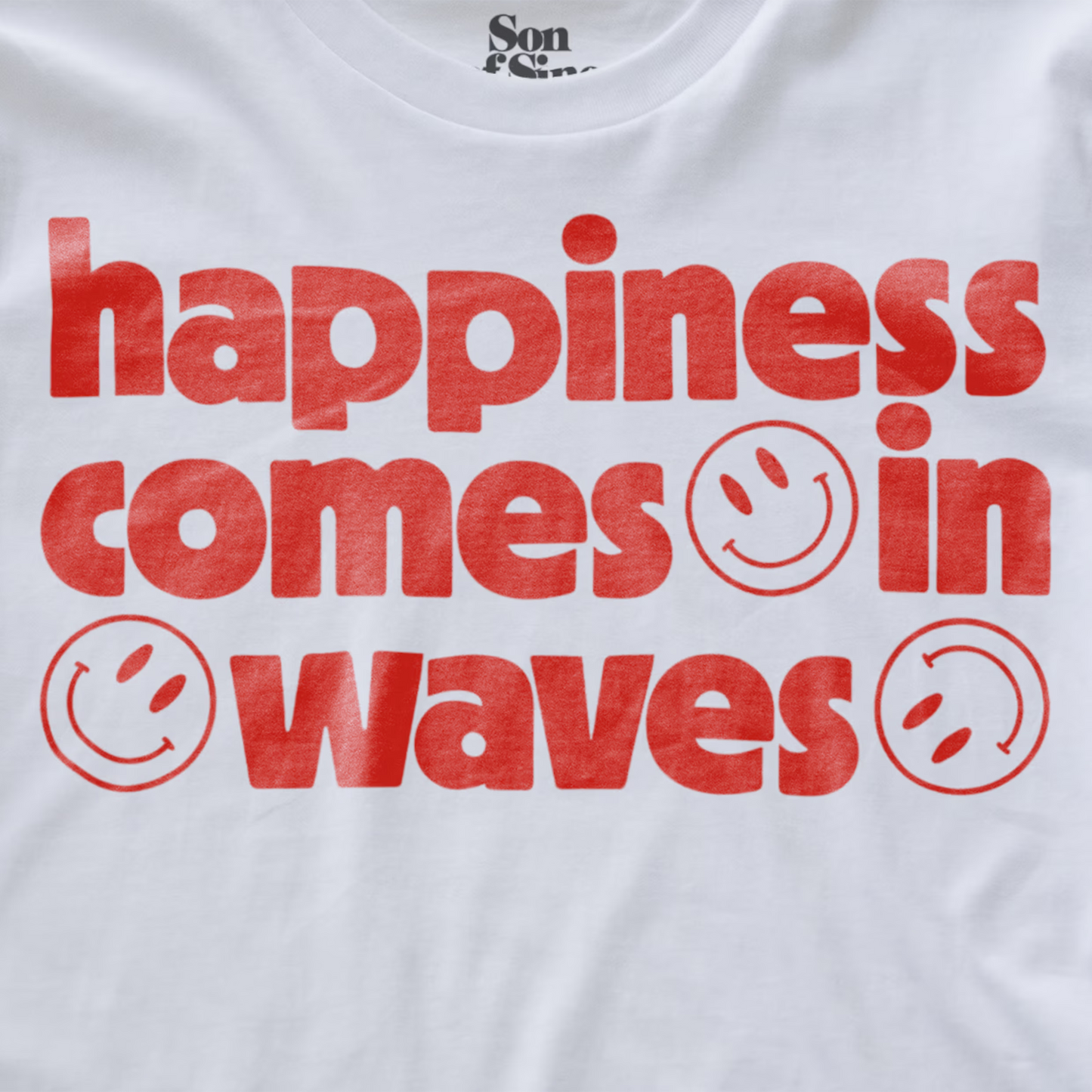 Close up of a white synth inspired  t-shirt with a red graphic text print reading 'happiness comes in waves' with smiley faces.
