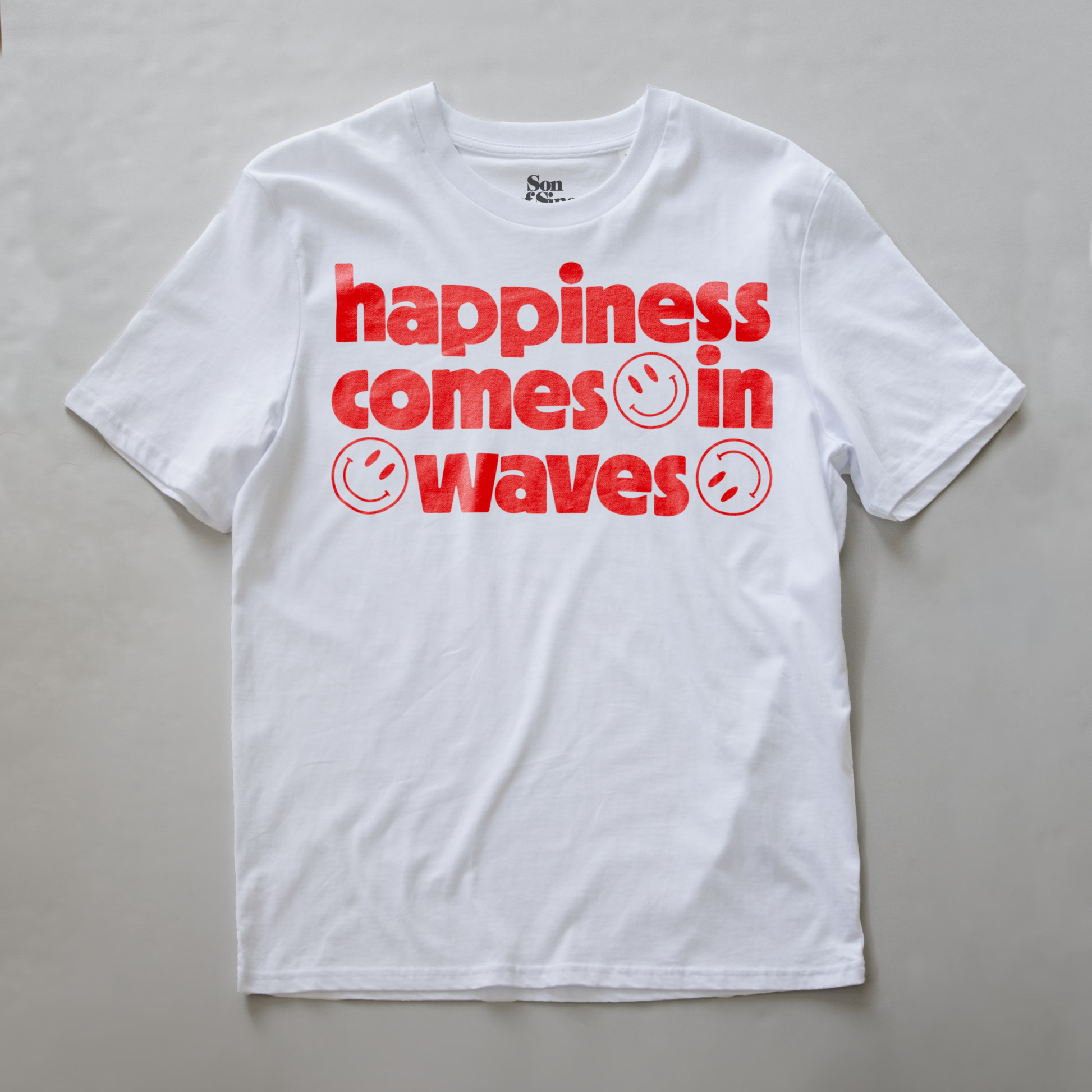 A white synth inspired  t-shirt with a red graphic text print reading 'happiness comes in waves' with smiley faces.