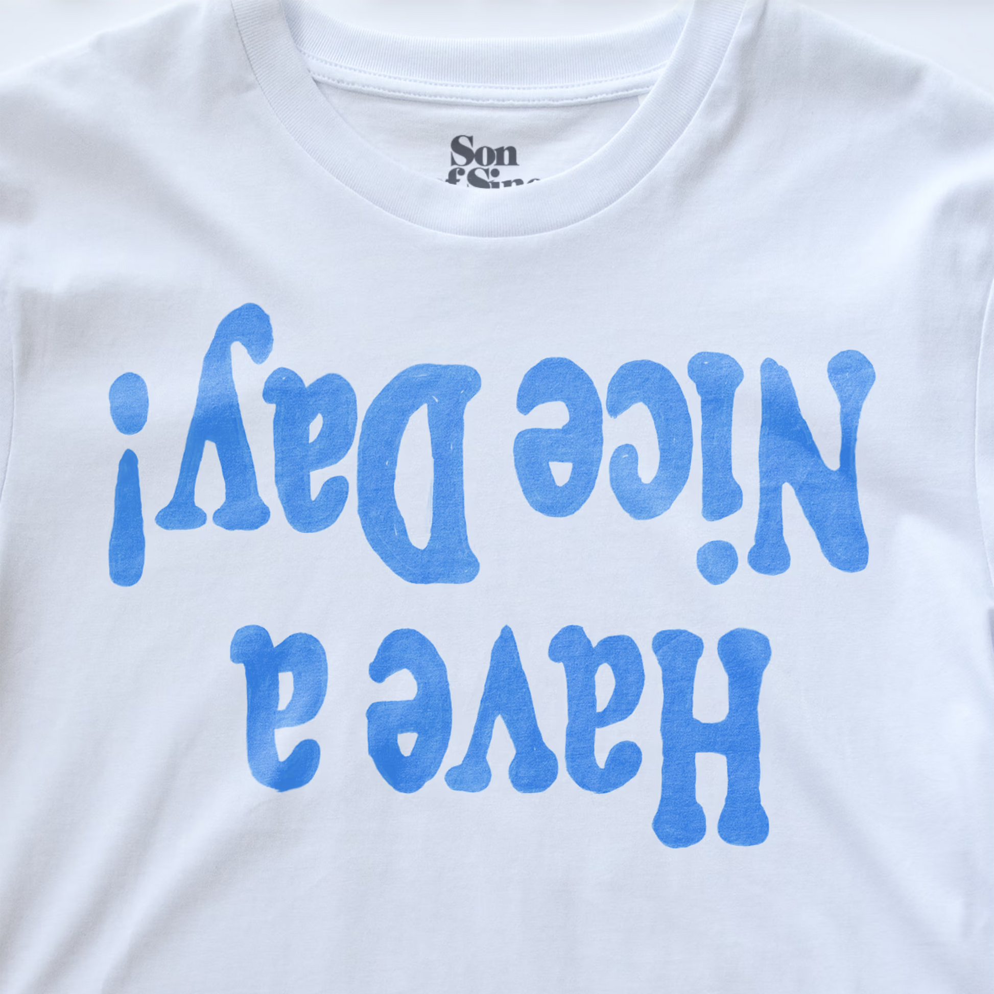 White electronic music festival t-shirt with 'Have a Nice Day!' printed in blue retro-style lettering on the front, with the brand name 'Son of Sine' visible inside the collar.