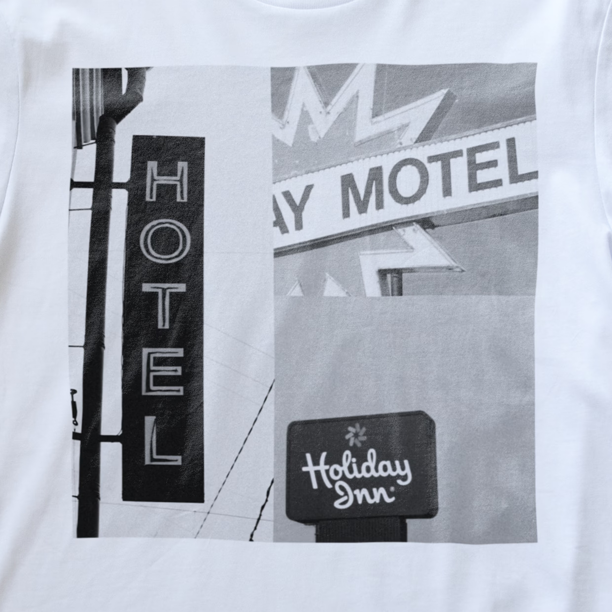 Close up of a white electronic music t-shirt featuring a black and white graphic print of a vintage signs with 'Hotel, 'Motel' and 'Holiday Inn' written on it.