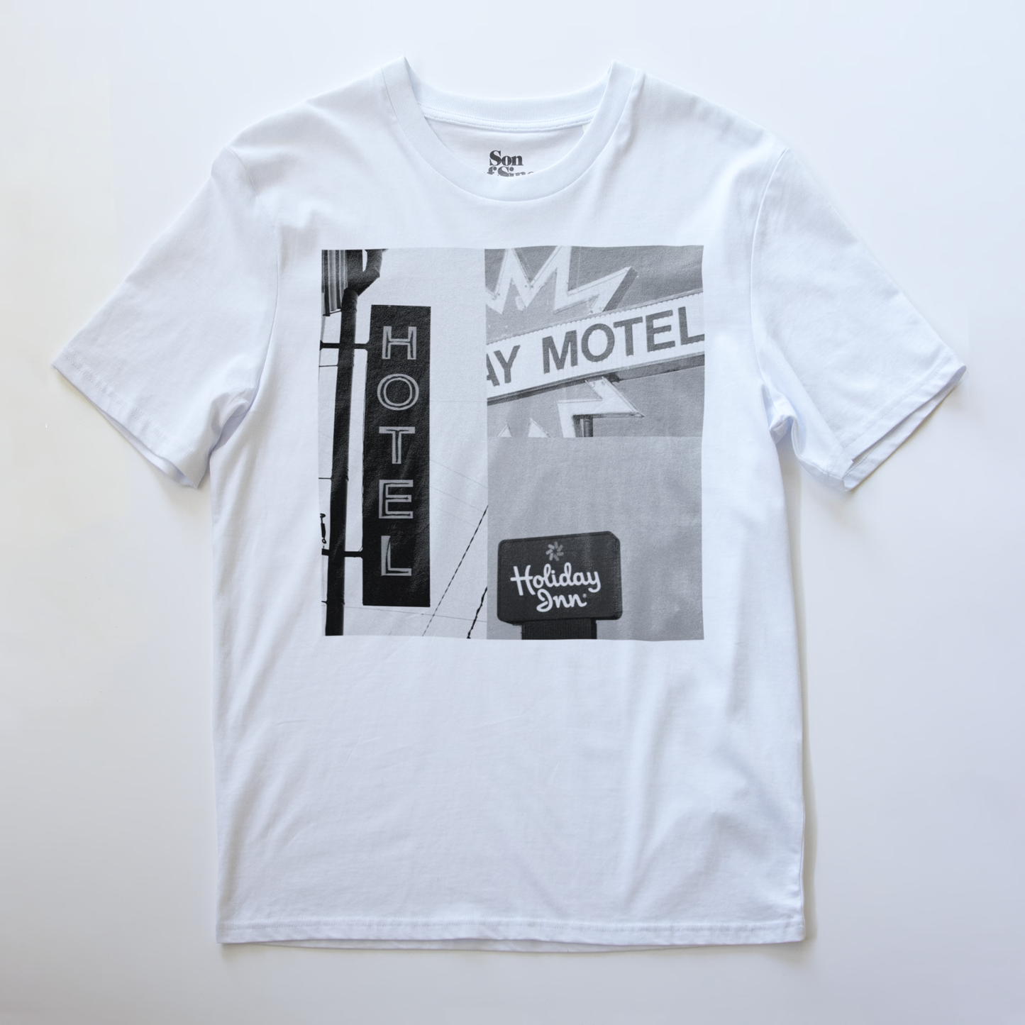 A white electronic music t-shirt with a black and white print of a vintage motel signs featuring  'Hotel', 'Motel' and 'Holiday Inn'.