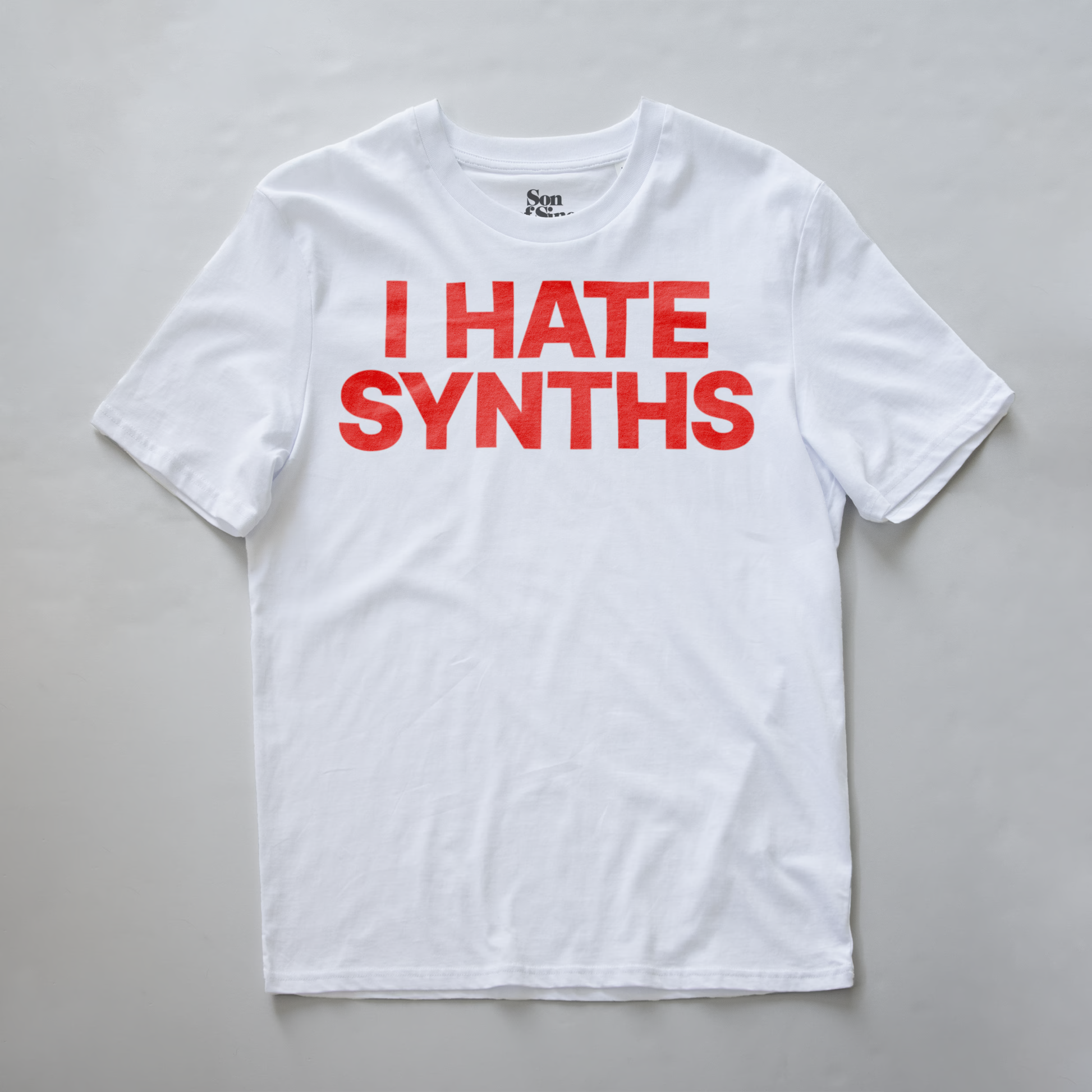 A white short-sleeve synth inspired t-shirt with the funny phrase 'I HATE SYNTHS' printed in bold red letters across the chest.
