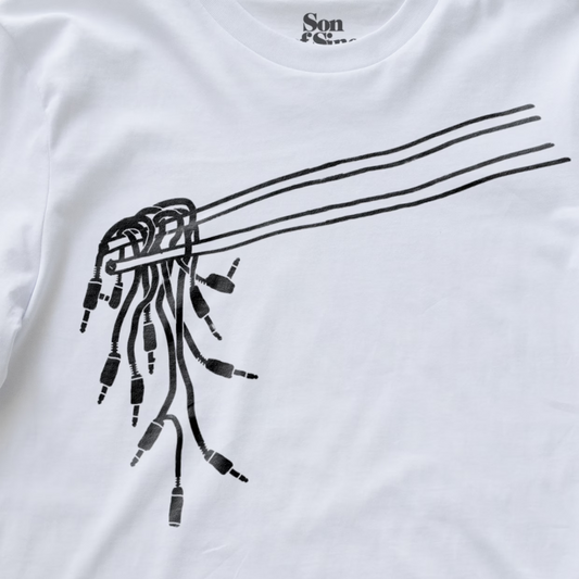 Close up of a modular synth t-shirt with a black line art graphic of chopsticks holding patching cables used for modular synths.