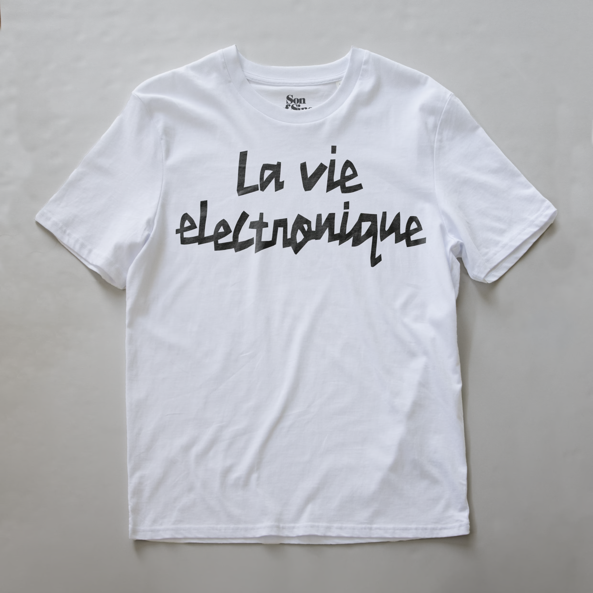 A white synth t-shirt with the phrase 'La vie electronique' printed across the chest in black script.
