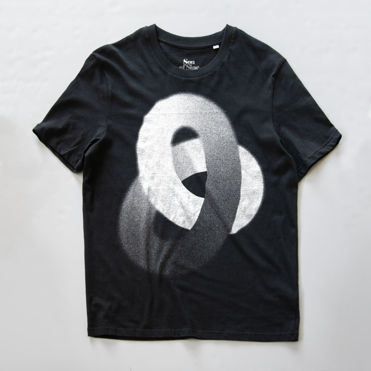 A black synth inspired t-shirt featuring a large, textured white and gray abstract knot-like graphic on the front.