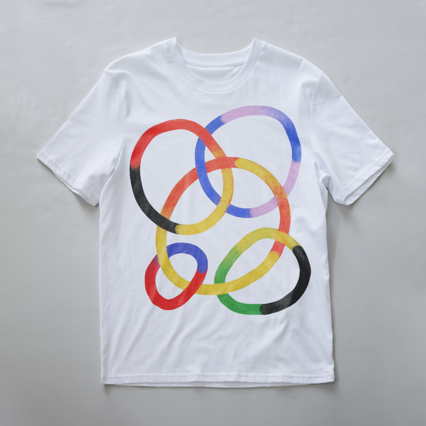 A white electronic music festival t-shirt featuring a graphic of overlapping watercolor-style rings in red, yellow, blue, purple, green, and black.