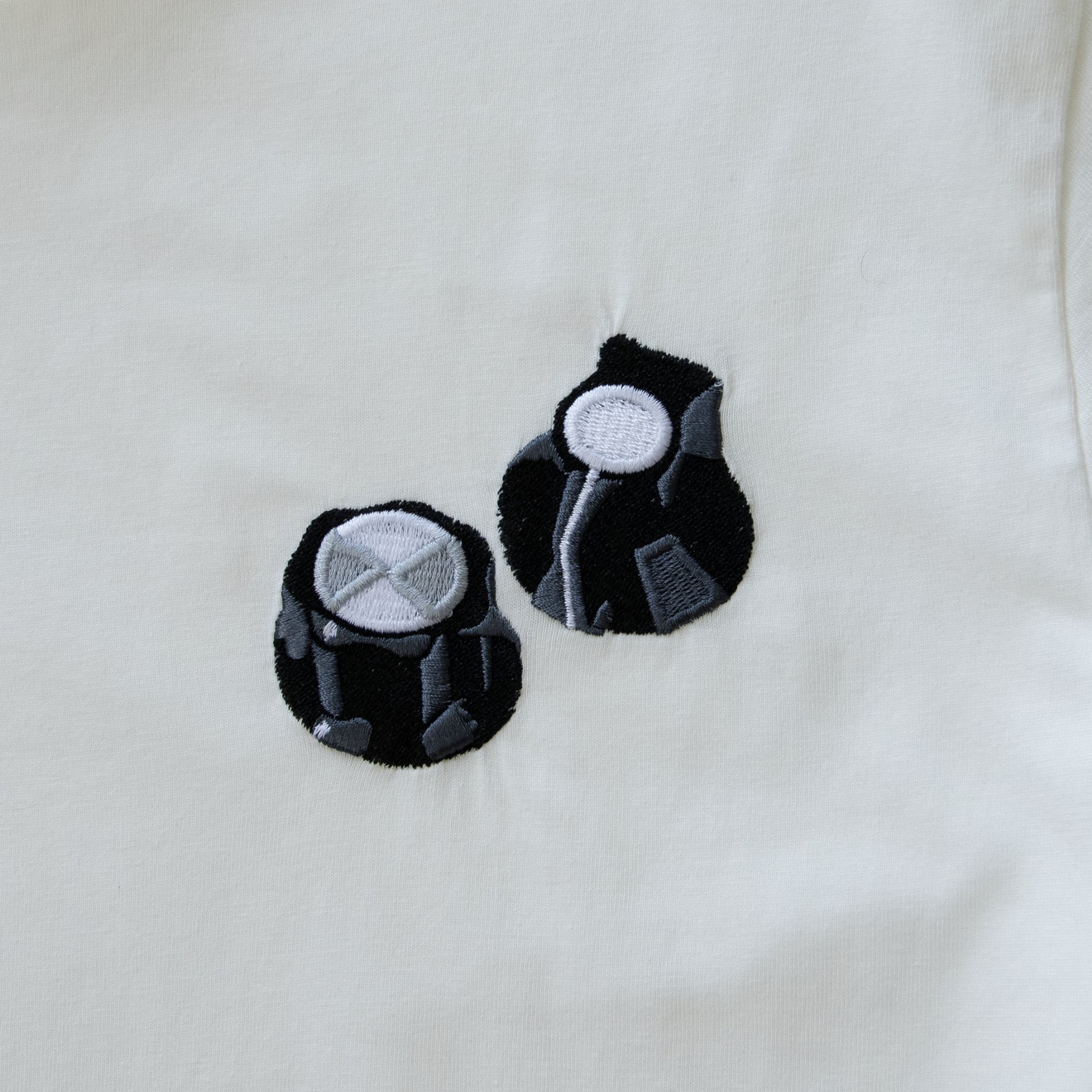 Two small embroidered modular synth knobs.