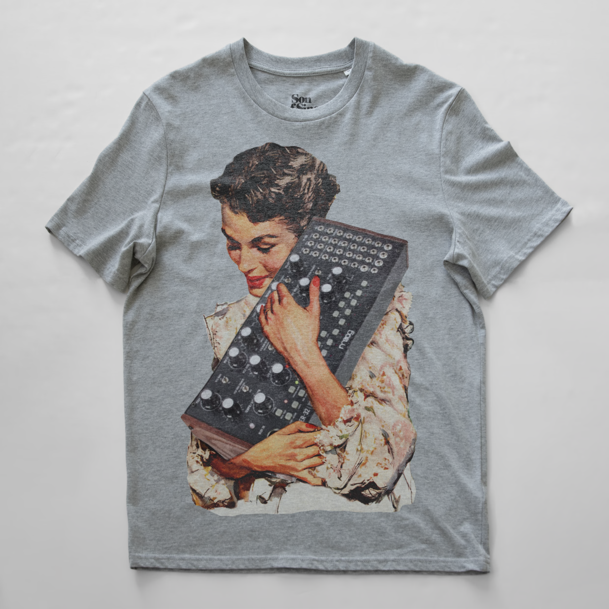 A heather gray synth t-shirt featuring a vintage-style graphic print of a woman holding a mother 32 modular synthesiser.