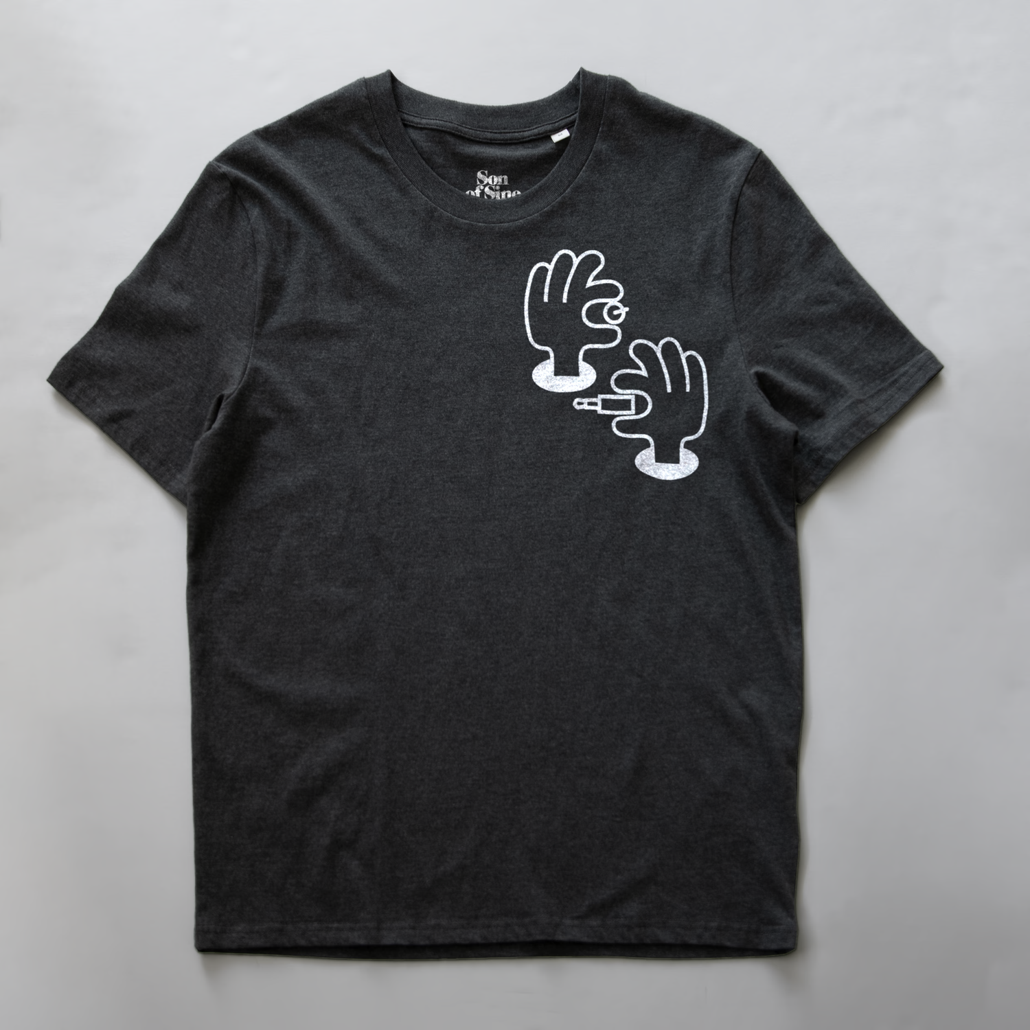 A dark heather gray synth inspired t-shirt with a white graphic illustration of two hands patching and tweaking electronic music.