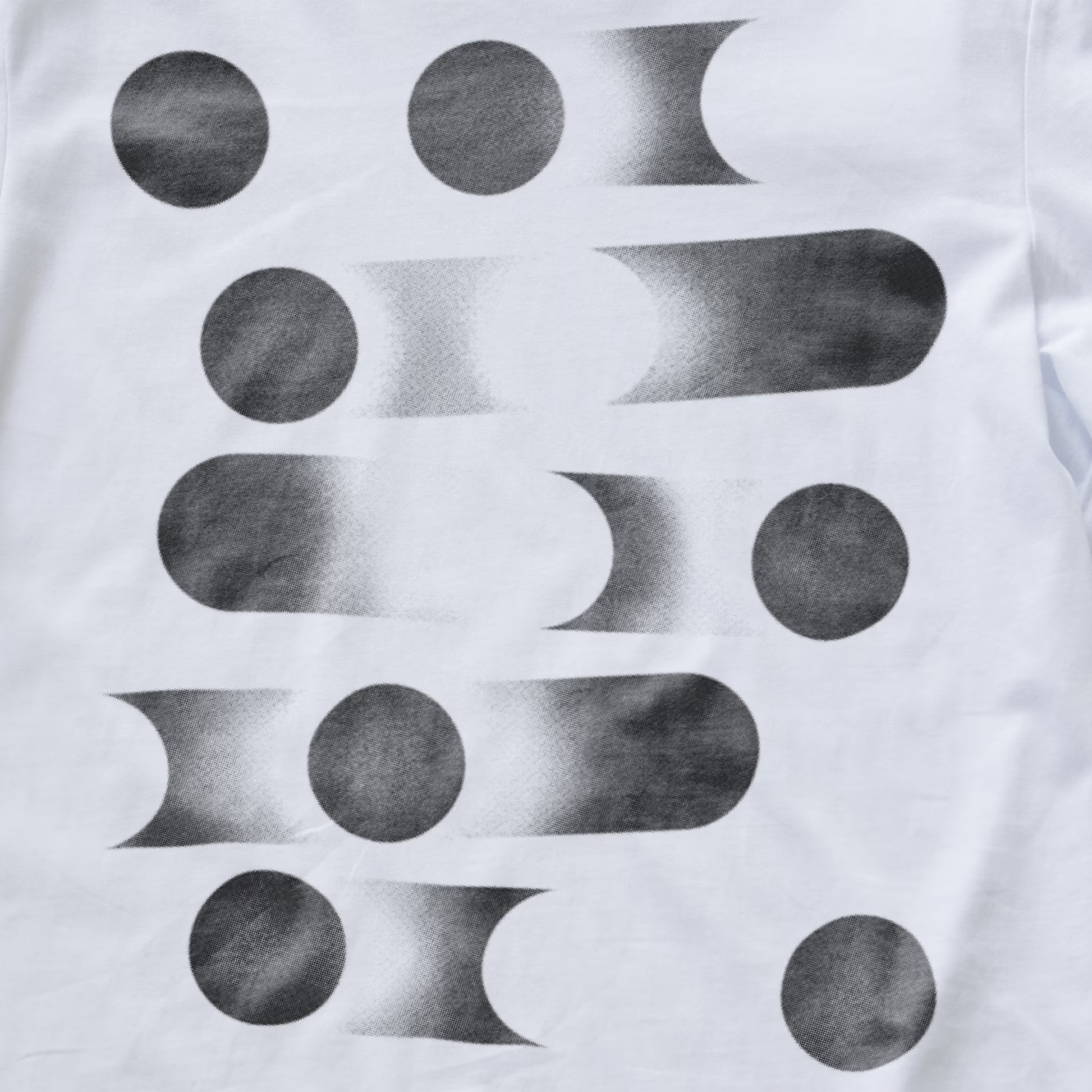 White modular synth t-shirt featuring a black and gray abstract geometric pattern of circles and elongated oval shapes with a textured, studded print.