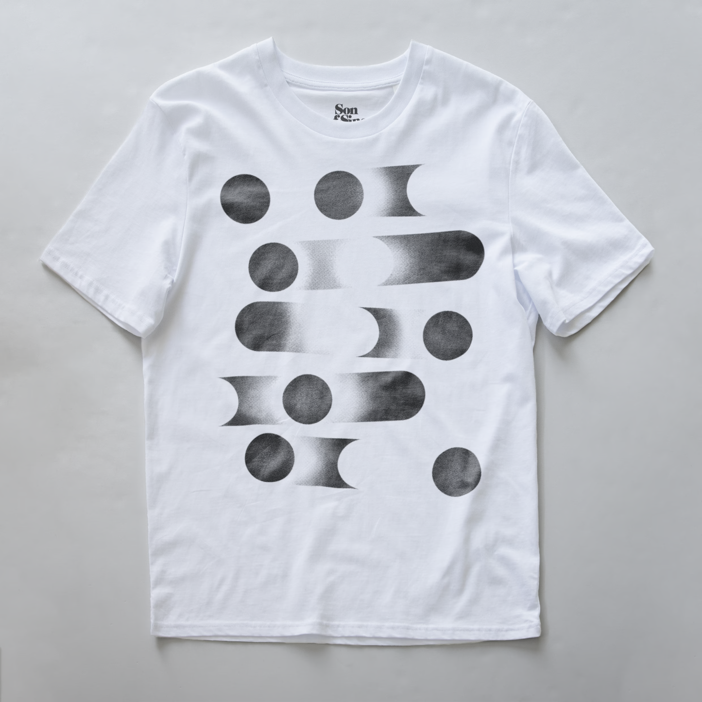 A white modular synth t-shirt with a black geometric abstract print of circles and gradient bars on the front.