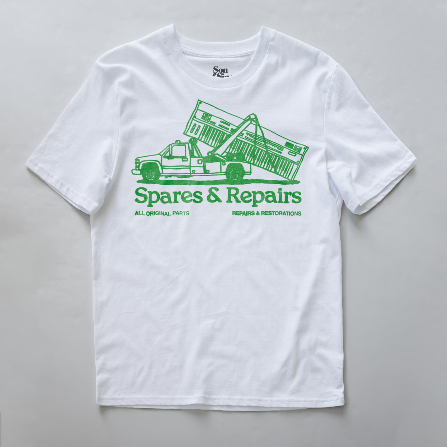 A synth inspired t-shirt with a green graphic of a tow truck carrying a synth and the text 'Spares & Repairs' printed on the front.