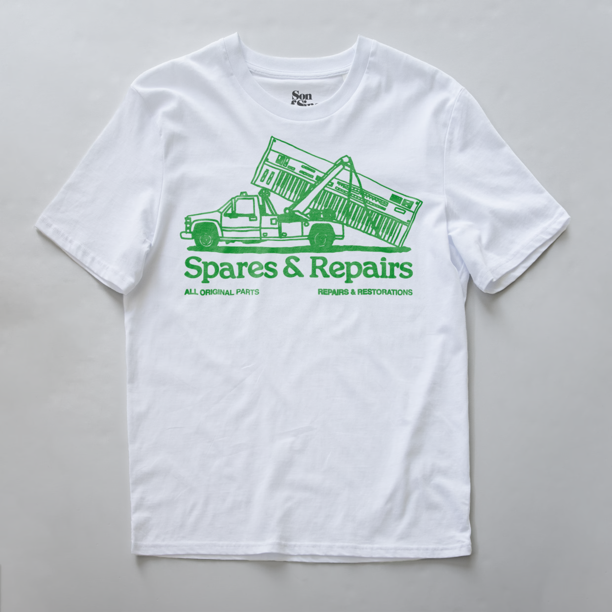 A synth inspired t-shirt with a green graphic of a tow truck carrying a synth and the text 'Spares & Repairs' printed on the front.