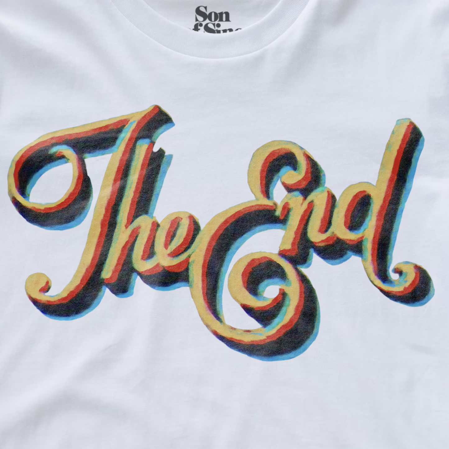 White synth t-shirt featuring a large graphic print of the word 'The End' in a stylized cursive font with a 3D rainbow shadow effect.