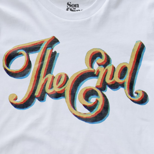 White synth t-shirt featuring a large graphic print of the word 'The End' in a stylized cursive font with a 3D rainbow shadow effect.